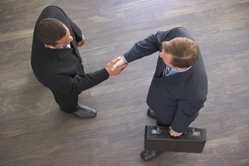 Two businessmen indoors shaking hands